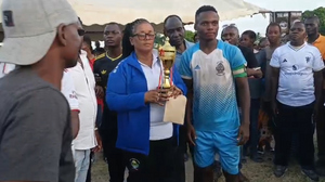 Sabaki Ward MCA Rose Baraka, in blue sports jacket, presents trophy to Sandoki FC champions after 1-0 victory over Blessed FC
