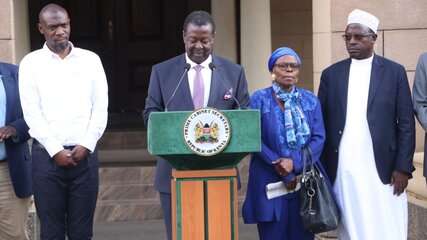 Musalia Mudavadi addressing the media at his office in Nairobi where he is accompanied by Stephen Munyakho popularly known as Stevo (left) and Stevo's mother, Dorothy Kweyu (right)