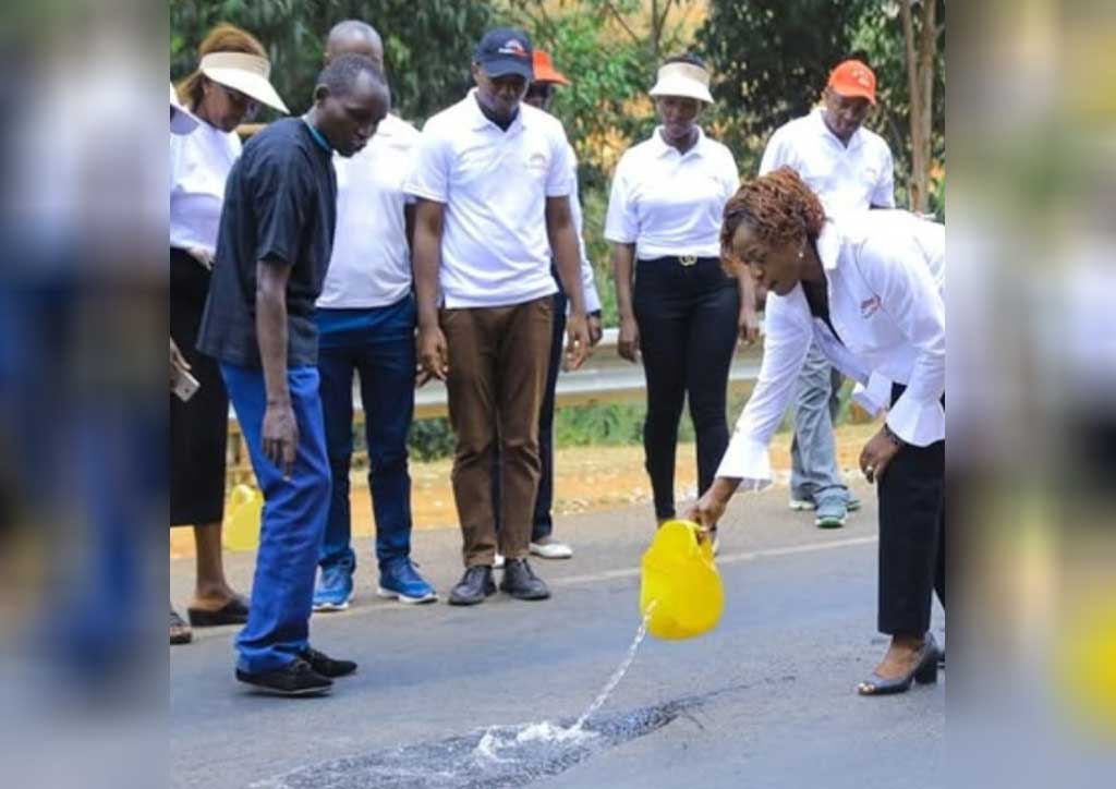 A woman pours water on Kyamwilu Hill near Machakos, witnessing it seemingly flow uphill, as her colleagues look on in amazement at this gravity-defying phenomenon.